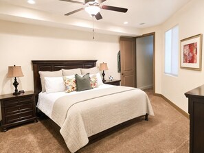 A bedroom with a bed, nightstands, a ceiling fan, a door, and a framed picture on the wall. - Two heated pools/spas, pond, backyard w/ BBQ (Washington)