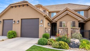 A two-story house with a garage, stone accents, and a well-maintained front yard. - Two heated pools/spas, pond, backyard w/ BBQ (Washington)