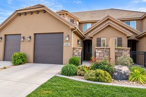 A two-story house with a garage, stone accents, and a well-maintained front yard. - Two heated pools/spas, pond, backyard w/ BBQ (Washington)
