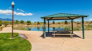 A gazebo with a picnic table, a lamp post, and a body of water in the background. - Two heated pools/spas, pond, backyard w/ BBQ (Washington)