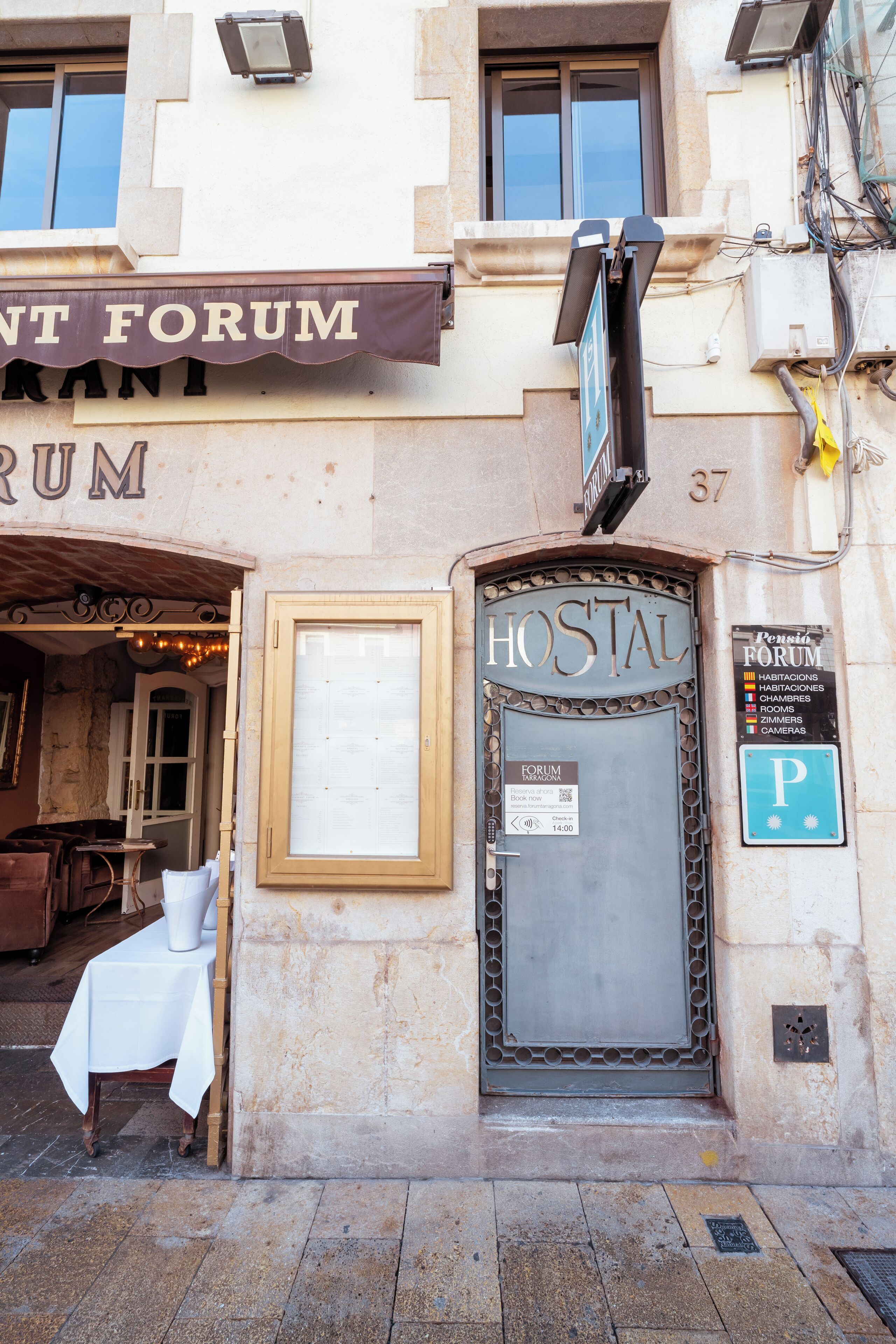 A building with a sign reading "HOSTAL" and a "P" parking sign.