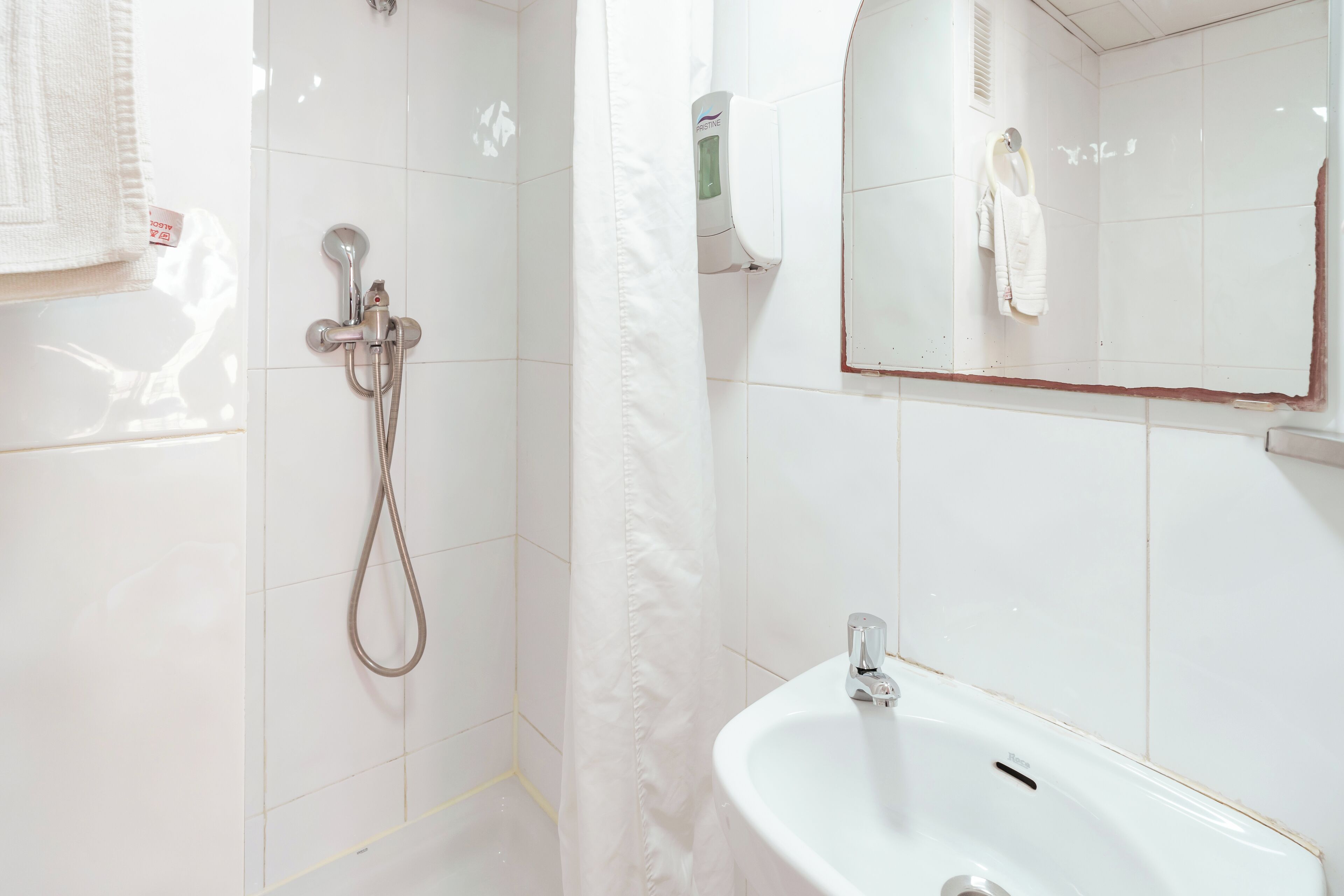 A bathroom with a shower, a sink, and a mirror.