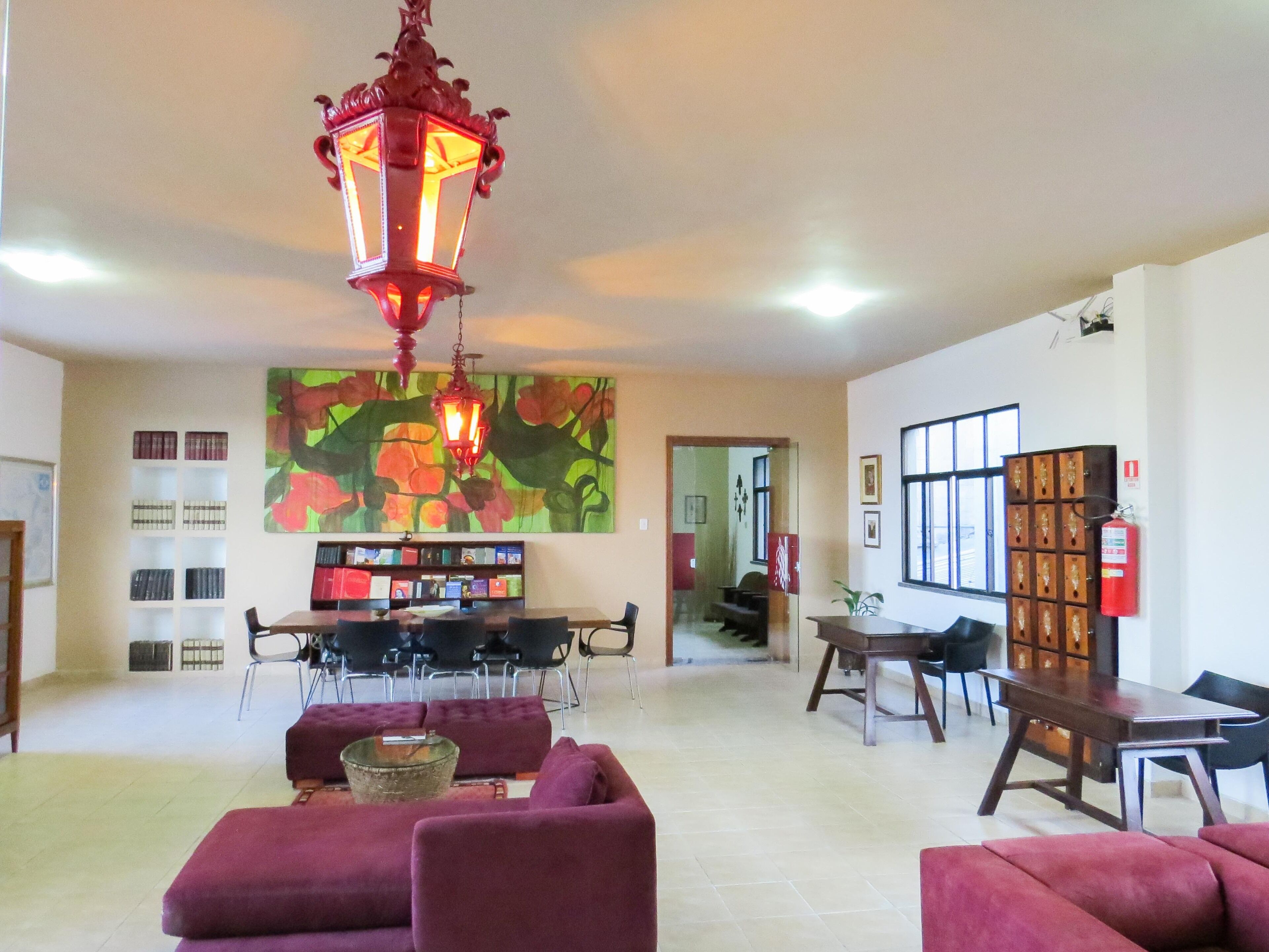 A spacious living area with a large bookshelf, a dining table, and comfortable seating.