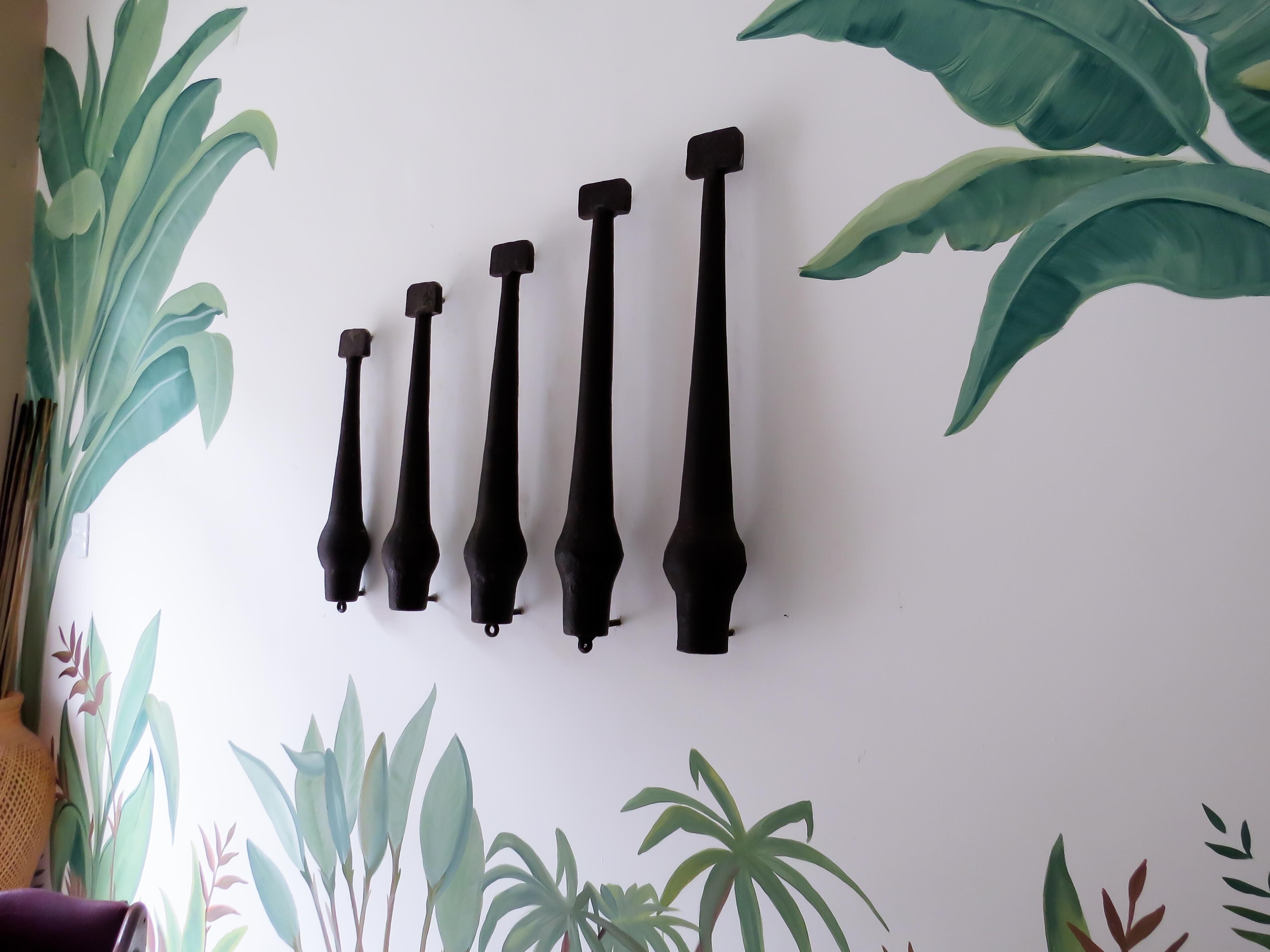 A wall with a series of black objects arranged in a row.