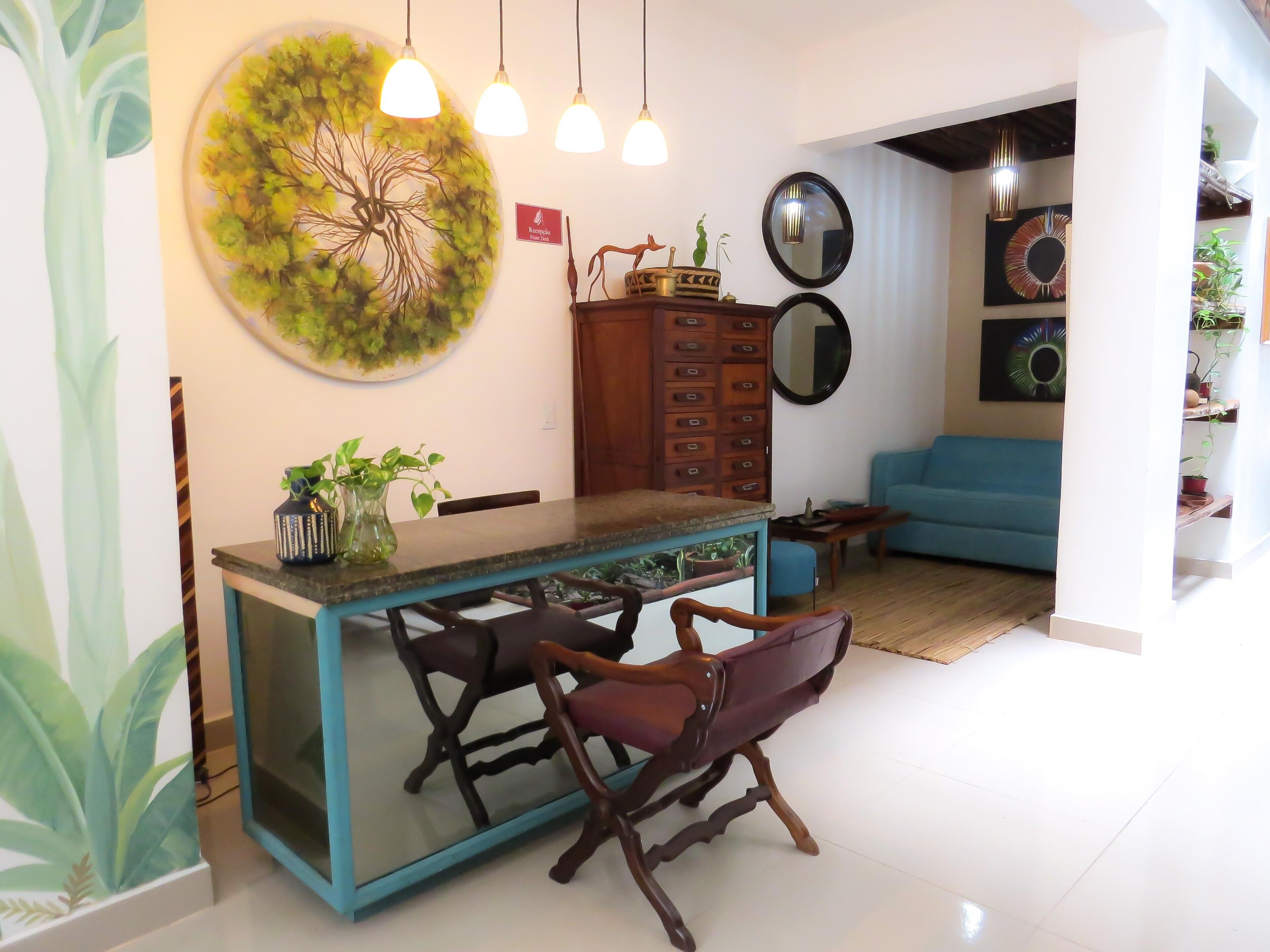 Un espace repas moderne avec une table à plateau en verre, des chaises en bois et un mur d’accent bleu.