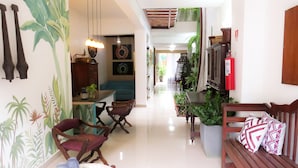 Un pasillo con comedor, muebles de madera y plantas en macetas.