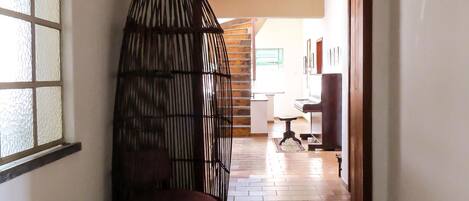 A hallway with a wooden bench, a wicker chair, and a wooden chest.