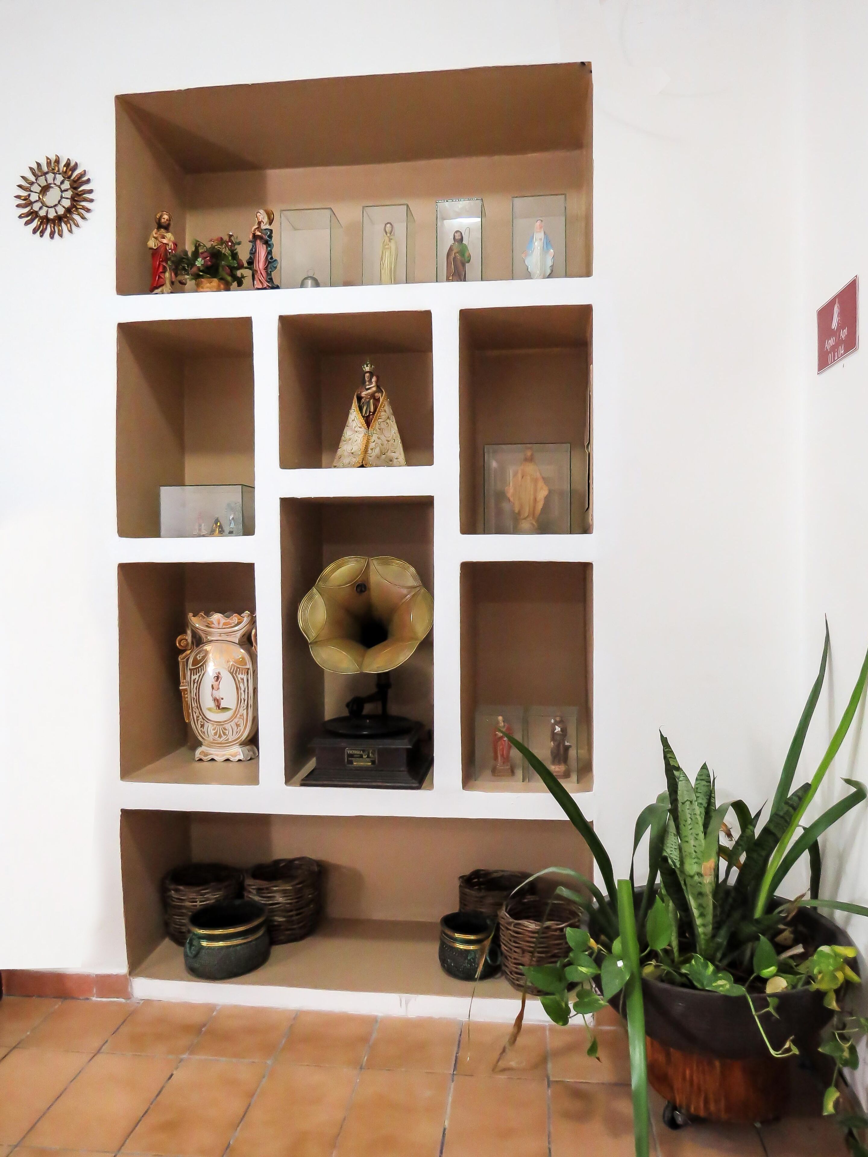 Una repisa con diversos objetos decorativos, incluyendo figuritas y un tocadiscos.