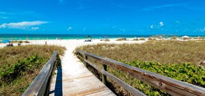 A wooden boardwalk leading to a beach with clear blue water and a few beach umbrellas. - Heated Pool + Ping-Pong + Foosball + 12 min to Beach (Sarasota)