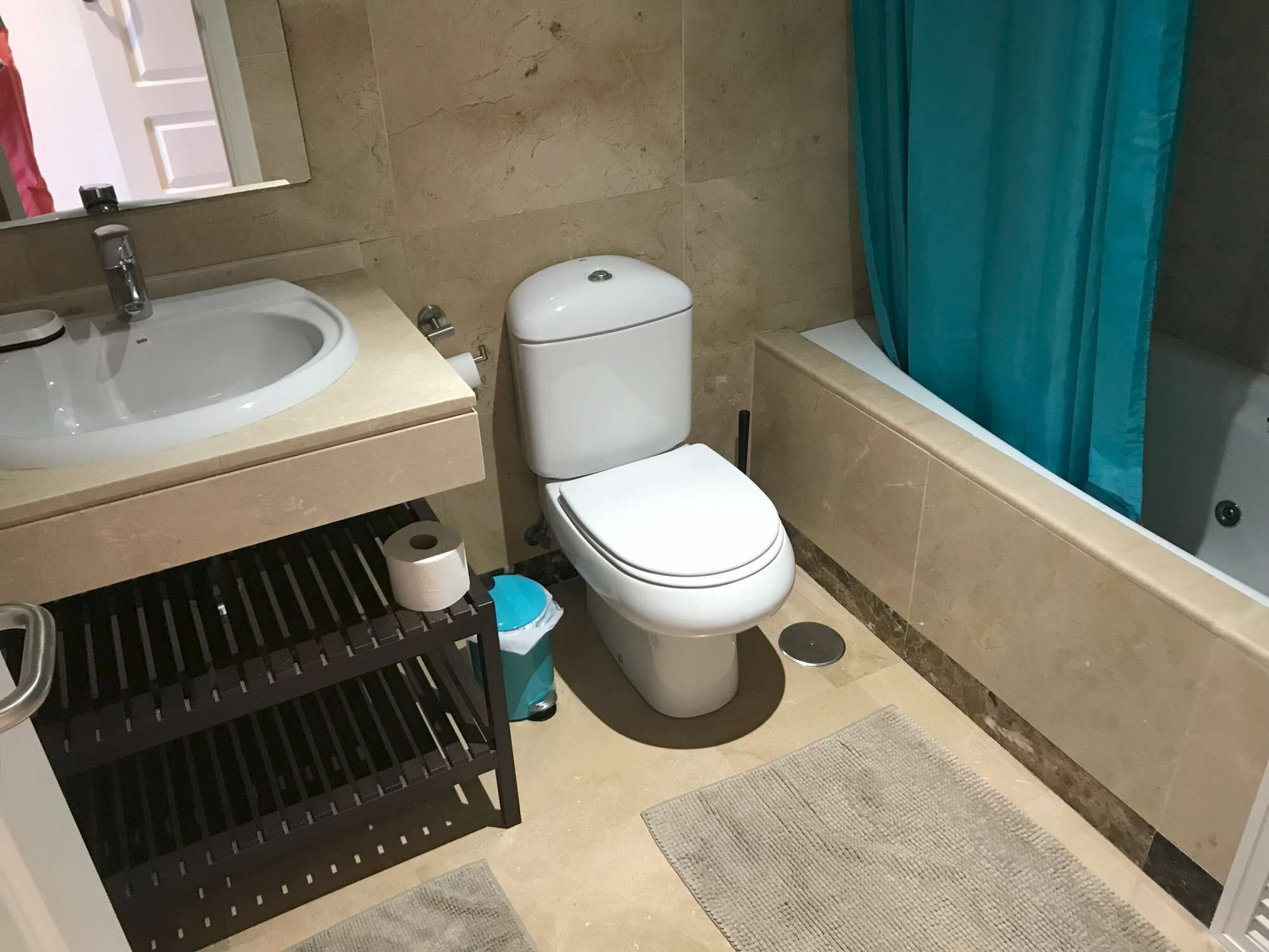 Een badkamer met een wastafel, toilet en bad.