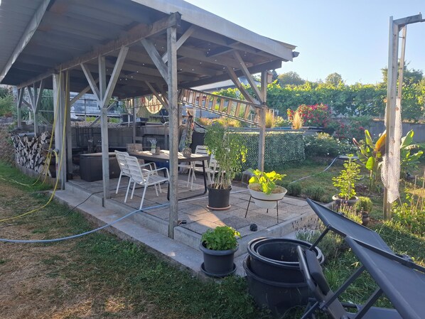 An outdoor patio with a covered seating area, a table, and chairs. - Moderne, Top Ausgestattete, Ruhige, Barrierefreie Ferienwohnung (Nonnweiler)