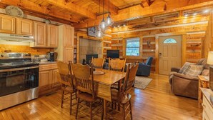 A wooden interior with a kitchen, dining area, and living room. - Creekside, Hot Tub, Fire Pit, Fireplace, Quiet, Easy Access (Cosby)