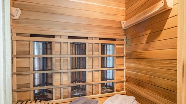A sauna with wooden benches and a bench with towels. - Cosy apartment close to Kaprun and Kitzbühel (Stuhlfelden)