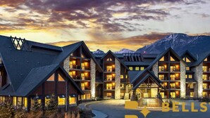 A multi-story hotel with a modern architectural design, featuring large windows and a stone facade.