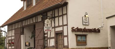 A traditional half-timbered building with a sign reading "Schrankenstich."