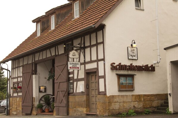 A traditional half-timbered building with a sign reading "Schrankenstich."