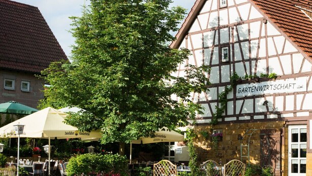 A traditional half-timbered building with a sign reading "Gartenwirtschaft." - Apartment in the Schnakenstich, 80 m², 2 bedrooms, living room, eat-in kitchen... (Hochdorf)