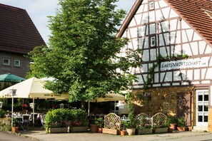 A traditional half-timbered building with a sign reading "Gartenwirtschaft."