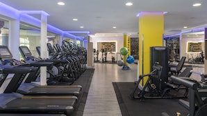 Un gimnasio con cintas de correr, elípticas y equipo de pesas.