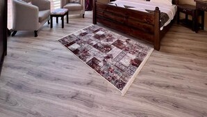 Een ruime kamer met een groot bed, twee fauteuils, een rond dakraam en uitzicht op een canyon.