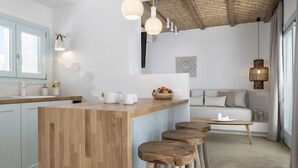 Une cuisine moderne avec un îlot central en bois, des tabourets de bar, des luminaires suspendus et un plafond au style rustique.