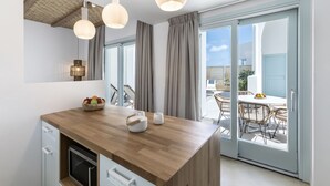 Une cuisine moderne avec un plan de travail en bois, un saladier rempli de fruits et une machine à café.