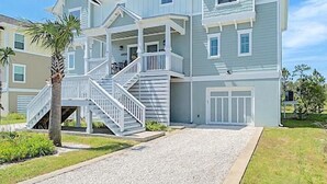 Une maison à deux étages avec un porche à l’avant, un escalier et un garage.