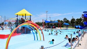 Ein Wasserpark mit mehreren Schwimmbecken, einer Rutsche und verschiedenen Spielbereichen.