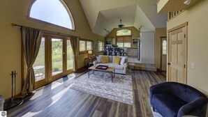 A spacious living room with a high ceiling, a large window, and a view of the outdoors. - Live the Vineyard Life at The Grand View 2 @ Willow Winery (Suttons Bay)