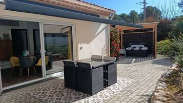 Enjoy al fresco dining and relaxation in this outdoor space with a patio area featuring a dining table, comfortable seating, and a barbecue grill.