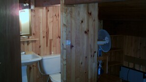 A wooden-paneled bathroom with a sink, toilet, and a fan. - Location Appartement 6 Personnes - Les Angles (Les Angles)