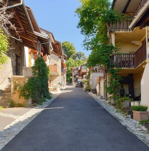 Calle estrecha bordeada por edificios tradicionales con balcones y fachadas de madera.