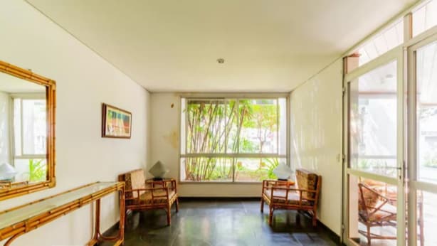 A room with a large window, two chairs, a small table, and a mirror on the wall. - In the best place in higienopolis 1 bedroom 1vaca (SP)
