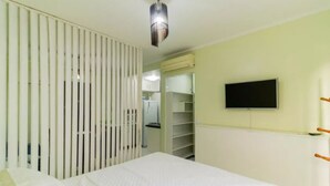 A bedroom with a bed, a wardrobe, a television, and a ceiling fan. - In the best place in higienopolis 1 bedroom 1vaca (SP)