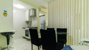 A compact living space with a kitchenette, a dining area with two chairs, and a small table. - In the best place in higienopolis 1 bedroom 1vaca (SP)