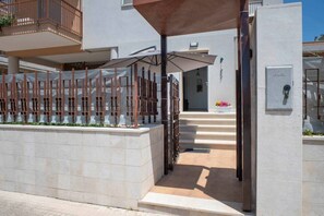 A gated entrance with a covered walkway leading to a building entrance.