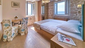 Une chambre à coucher avec un lit, un bureau, une chaise et une fenêtre donnant sur un beau paysage.