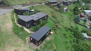 A modern residential area with detached houses featuring flat roofs and large windows. - Harbour Escape - tiny home in Lyttelton with Port Views (Lyttelton)