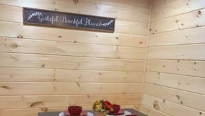 A wooden-paneled room with a table set for four, each with a red bowl and a placemat. - Cedar Lodge, serene all wood escape in Blue Ridge (Newland)