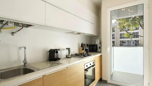 Una cocina moderna con un lavamanos de acero inoxidable, una cafetera, un tostador y una estufa.