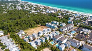 A coastal residential area with modern houses, a beach, and a clear view of the ocean.