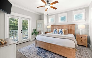 A bedroom with a bed, ceiling fan, bedside tables, and a nightstand.