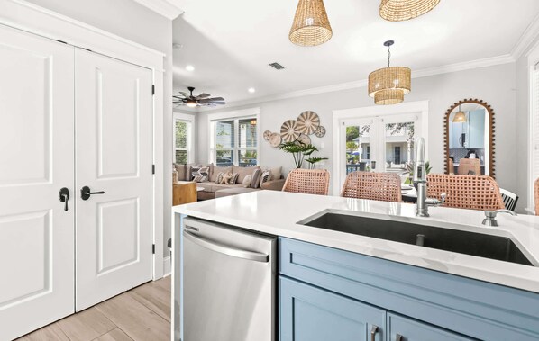 A kitchen with a white countertop, stainless steel appliances, and blue cabinets.
