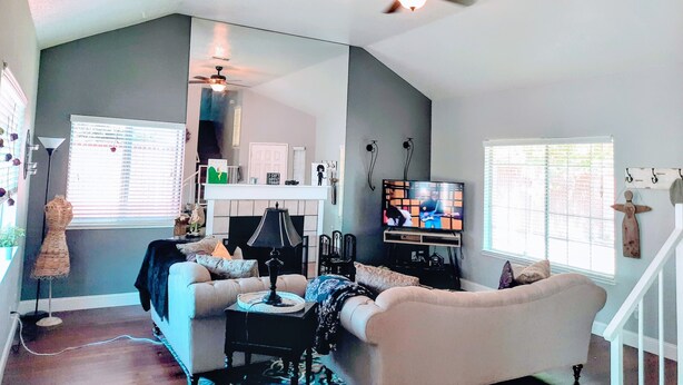 A living room with a sofa, a coffee table, a television, and a ceiling fan. - Huge Peaceful & Cheerful Home (Redding)