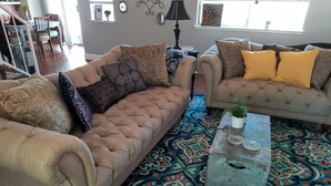 A living room with two sofas, a patterned rug, and a metal coffee table. - Huge Peaceful & Cheerful Home (Redding)