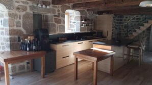 A rustic kitchen with stone walls, wooden furniture, and a built-in island.