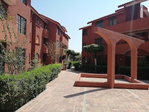 Stroll through the charming courtyard, surrounded by lush greenery and historic architecture.