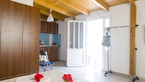 Un dormitorio con cama, armario de madera, baño con lavamanos y vistas al exterior.