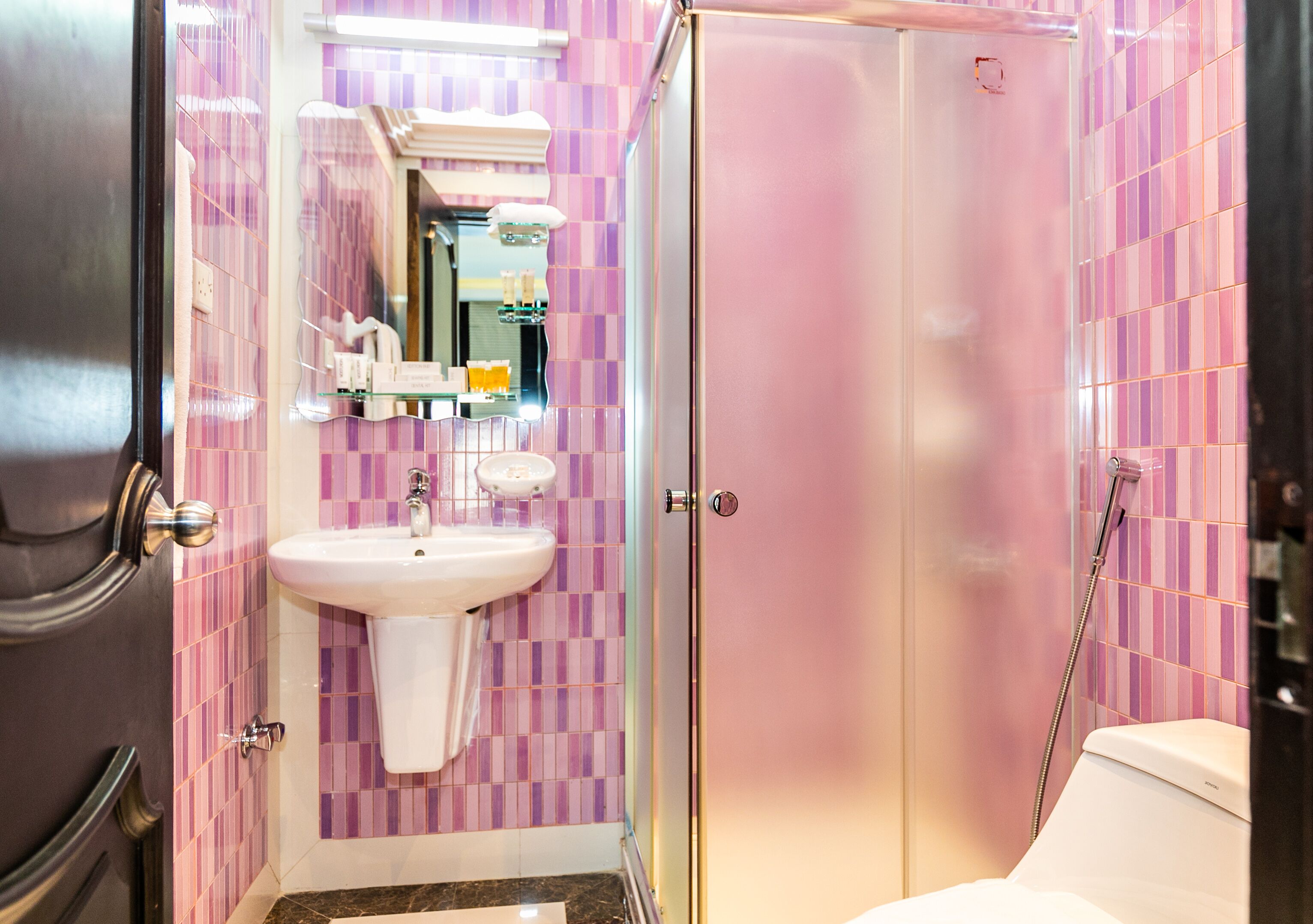 A bathroom with a white sink, a mirror, and a shower enclosure.