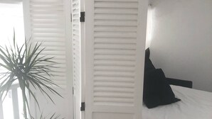 A bedroom with a bed, a potted plant, and a white wardrobe. - Villa 150 m2, 4 air-conditioned bedrooms 8/10pers swimming pool, close to beaches  (La Ciotat)